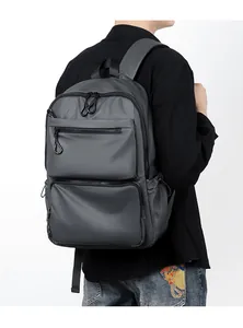 Rear view of a model wearing a grey water-resistant backpack with multi-layer zipper pockets