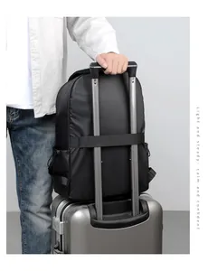 Detail of black travel backpack with luggage strap fixed on silver suitcase handle