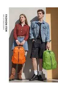 Detalle de mochilas de nailon impermeable en naranja y verde con cremallera vertical moderna
