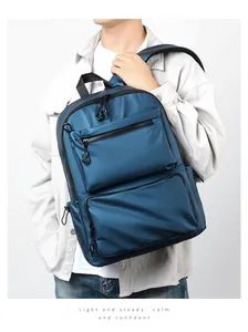 Detail view of water-resistant navy blue backpack with large dual zipper front pockets