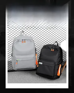 Detail of durable nylon backpack with reflective strips and vibrant orange zipper pulls