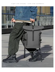 Zaino tattico grigio scuro con chiusura roll-top e fibbie regolabili in contesto urbano