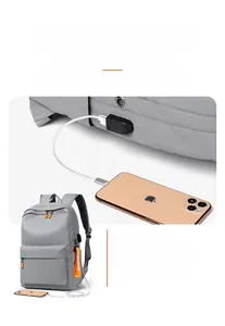 Detailed view of grey backpack with USB charging port and orange zipper accents