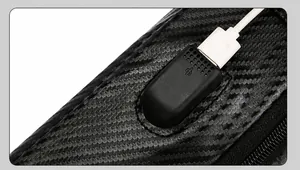 Detail of side USB charging port on black carbon fiber texture crossbody chest bag