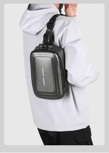 Close-up of black hard shell chest bag with carbon fiber texture and anti-theft lock