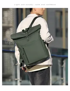 Detail of roll-top closure and matte waterproof fabric on deep green backpack