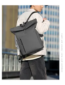 Outdoor shot of dark gray waterproof roll-top backpack on model with city background