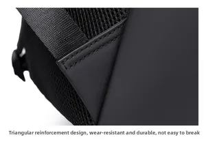Detail of reinforced triangular stitching and breathable mesh strap on black backpack