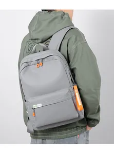 Detail view of water-resistant light grey backpack with orange zipper accents for travel