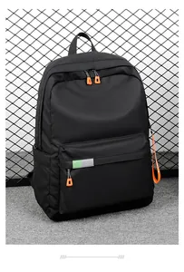 Detail of waterproof nylon backpack with orange zipper pulls and reflective safety strip