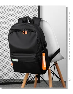 Detail of black nylon backpack featuring functional USB charging port and orange zipper
