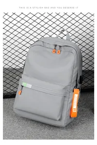 Detail of grey nylon backpack featuring orange zippers and external USB charging port