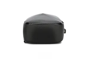 Detail of crossbody bag base featuring carbon fiber texture and external USB charging port