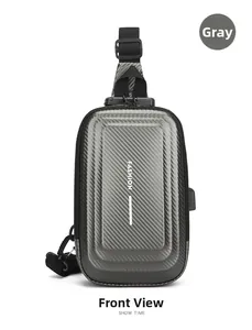 Detail of grey hard shell crossbody bag with carbon fiber texture and USB charging port