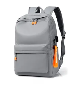 Detail of grey waterproof laptop backpack with orange zippers and external USB port