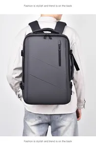 Dark grey business backpack with external USB port shown on male model from back view
