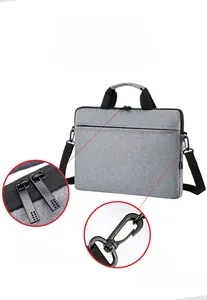 Detailed view of the dual metal zippers and detachable shoulder strap on grey laptop bag