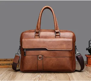 Brown leather briefcase with top handle and adjustable shoulder strap on wooden surface