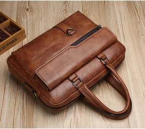 Close-up of caramel textured leather briefcase with metallic zippers and dual handles