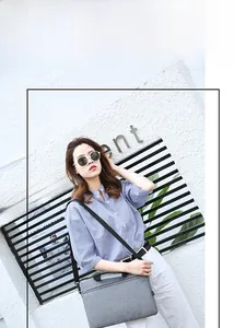 Detailed view of gray slim laptop bag with handle and adjustable crossbody shoulder strap