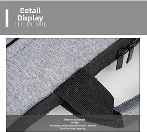 Detail of light grey laptop bag showing reinforced black webbing handle and double zippers