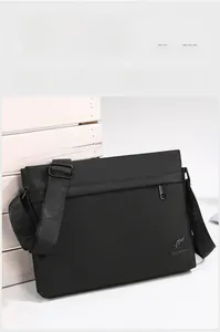 Detail of black oxford messenger bag with adjustable strap and kangaroo metal logo