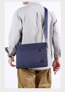 Rear view of a navy blue Oxford fabric messenger bag with adjustable branded strap