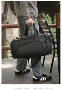 Detail of black travel duffel bag showing matte texture and side mesh pocket outdoors
