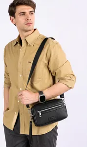 Gedetailleerde weergave van een zwarte leren heren messenger bag gedragen over de schouder