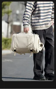 Close-up of cream travel backpack with side zipper pocket and durable side buckles