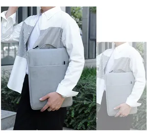 Light gray fabric laptop sleeve with carry handle and large front pocket shown outdoors