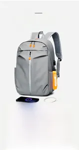 Detail of grey waterproof backpack showing external USB port and charging cable setup