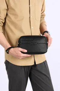 Detail einer schwarzen Herren-Clutch aus Leder mit HCDS-Prägung und feiner Lychee-Narbung