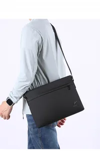 Close-up of black business casual crossbody bag featuring waterproof fabric and metal logo