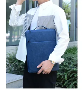 Detail of navy blue laptop sleeve with handle and zipper pocket held by professional
