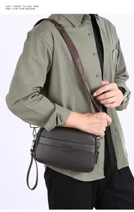Detail der Business-Tasche aus Leder mit Lychee-Muster, Logo und abnehmbarem Gurt