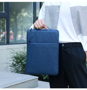 Dark blue laptop sleeve with integrated handle and front zipper pocket in urban setting
