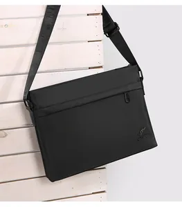 Close-up of black oxford cloth messenger bag with adjustable branded shoulder strap