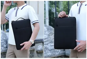 Minimalist black laptop sleeve with top handle and front zipper pocket shown in use