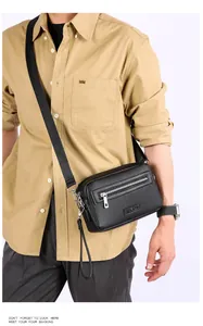 Detail van de heren crossbody tas in zwart leer met ritsvak en metalen gespsluiting