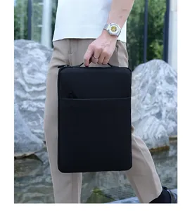 Outdoor lifestyle shot of a black laptop sleeve bag with handle and zipper pocket