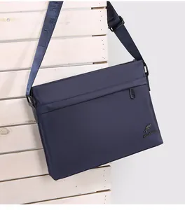 Detail view of navy blue waterproof nylon messenger bag with kangaroo metal logo and strap