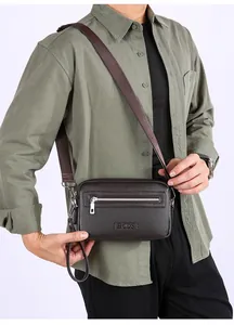 Detail van bruine crossbodytas met litchi-patroon, zilveren rits en HOOS-merklogo