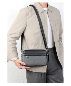 Uomo con borsa a tracolla nera in pelle intrecciata e tracolla in nylon regolabile