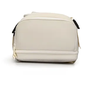 Detail view of the breathable mesh bottom and dual zippers on the beige outdoor backpack