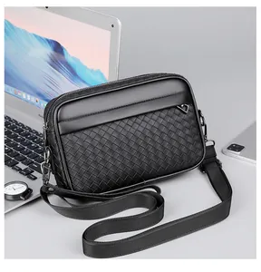 Dettaglio della trama in pelle intrecciata nera su una moderna borsa a tracolla da uomo