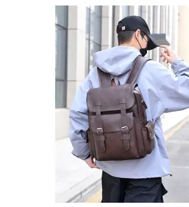Detail of vintage dark brown leather backpack showing flap closure and buckle straps