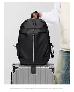 Detail of waterproof black travel backpack placed on a silver suitcase handle