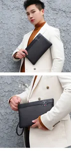 Detail of men's black lychee leather clutch with kangaroo metal logo and stripe accent