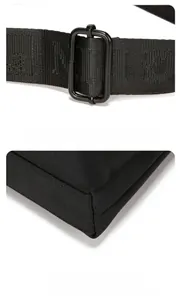 Detail of adjustable woven shoulder strap and wear-resistant corner on black oxford bag